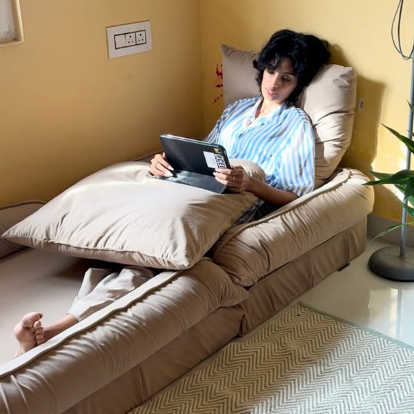 Woman sitting on a beige floor sofa reading